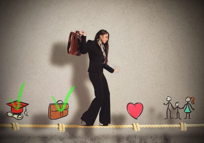 Woman walking tightrope to balance work life.